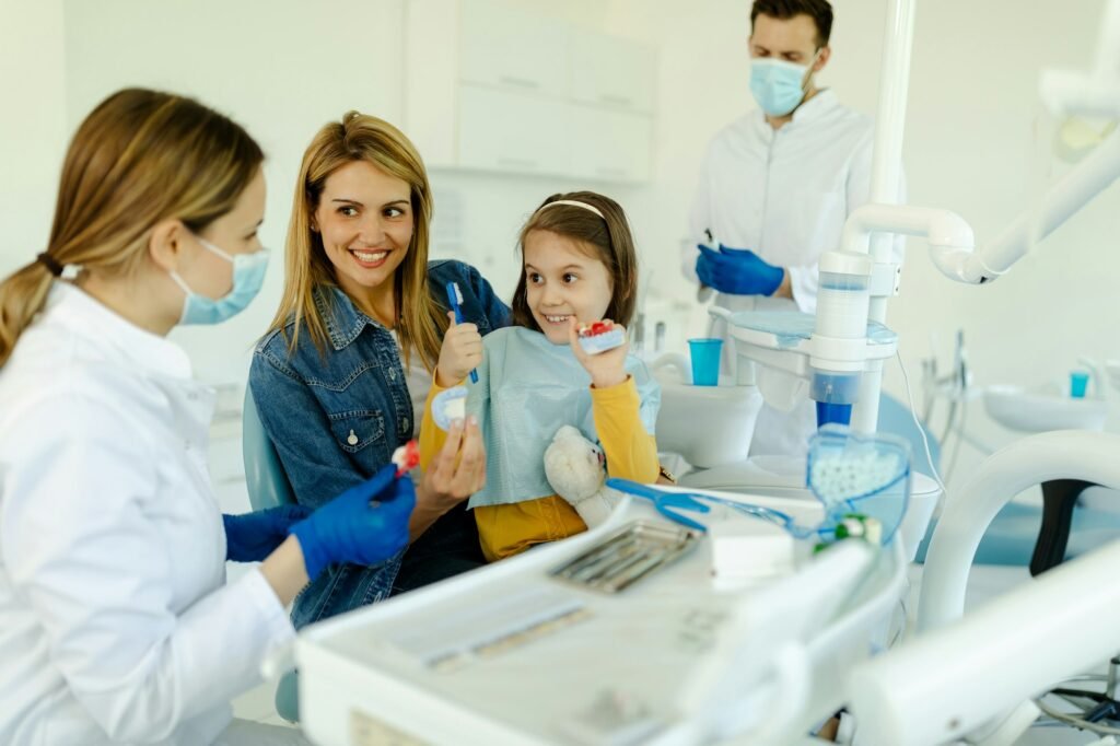 Happy mother and child seeing pediatric dentist.